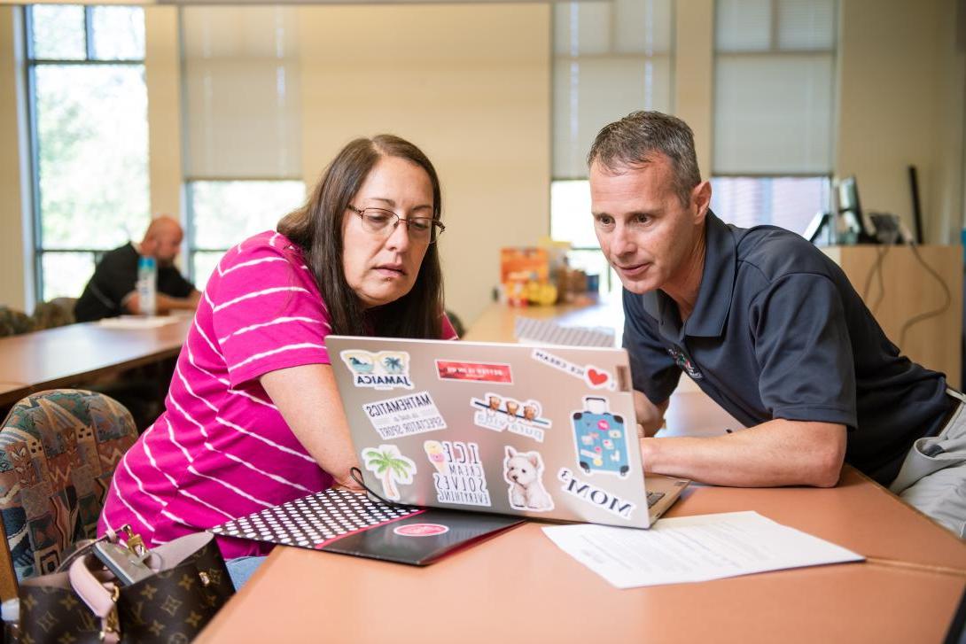 Principal licensure workshop - instructor helping a student on her computer