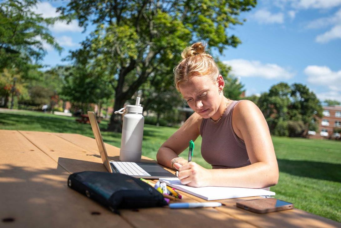 student studying at picnic table
